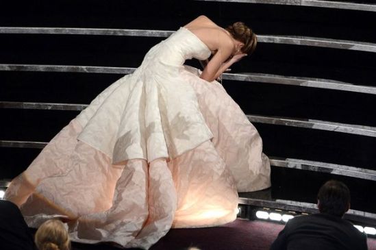 Best Actress winner Jennifer Lawrence trips up the stairs as she accepts her Oscar.(photo credit: Kevin Winter/Getty Images North America)